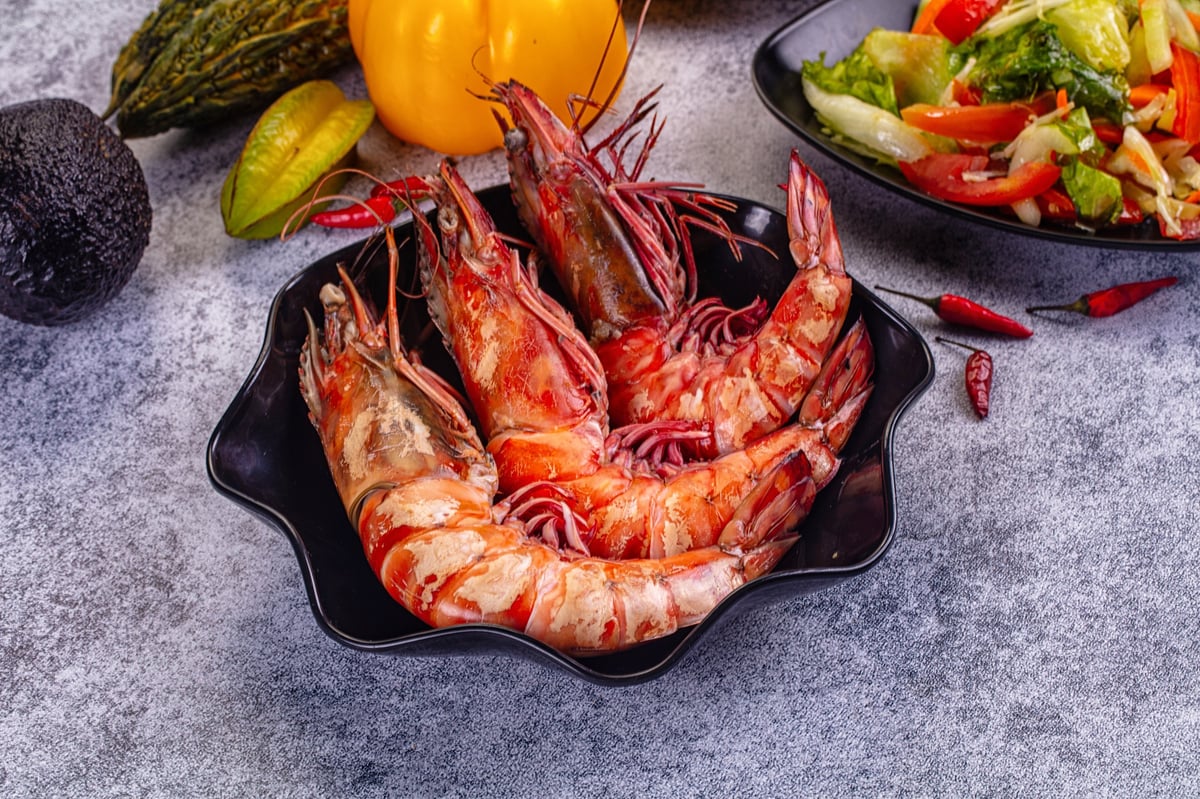 Vibrant tabletop view of cooked giant prawns in a black dish